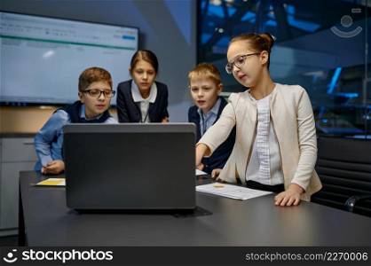 Diverse children business team looking at laptop screen analyzing financial data at conference room. Diverse children business team analyzing financial data
