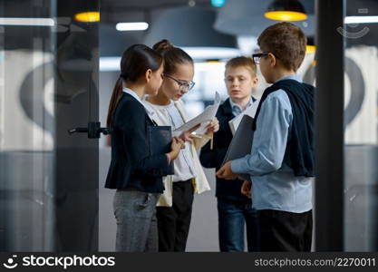 Diverse children professional business team discussing work sharing ideas in creative office. Children business team discussing work in office