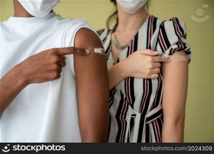 Diverse group of people showing COVID-19 vaccine bandage merrily in concept of coronavirus vaccination program to vaccinate citizen .. Diverse group of people showing COVID-19 vaccine bandage merrily