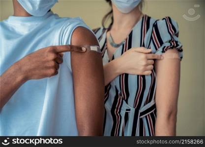 Diverse group of people showing COVID-19 vaccine bandage merrily in concept of coronavirus vaccination program to vaccinate citizen .. Diverse group of people showing COVID-19 vaccine bandage merrily