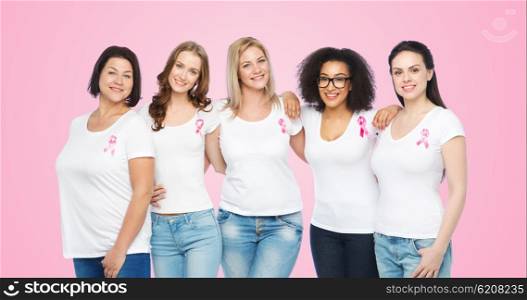 diverse, healthcare and people concept - group of happy different size women in white t-shirts with pink breast cancer awareness ribbon over pink background