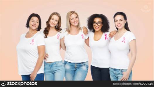 diverse, healthcare and people concept - group of happy different size women in white t-shirts with pink breast cancer awareness ribbon over beige background