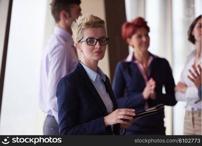 diverse startup business people group standing together as team in modern bright office interior with blonde woman with glasses in front as leader