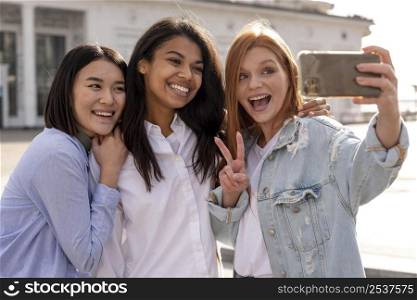diverse women taking selfie together