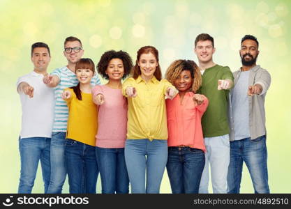 diversity, choice, ethnicity and people concept - international group of happy smiling men and women pointing finger on you over summer green lights background