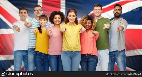 diversity, choice, ethnicity and people concept - international group of happy smiling men and women pointing finger on you over english flag background. international group of people pointing on you