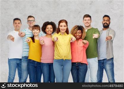 diversity, choice, ethnicity and people concept - international group of happy smiling men and women pointing finger on you over gray concrete background. international group of people pointing on you