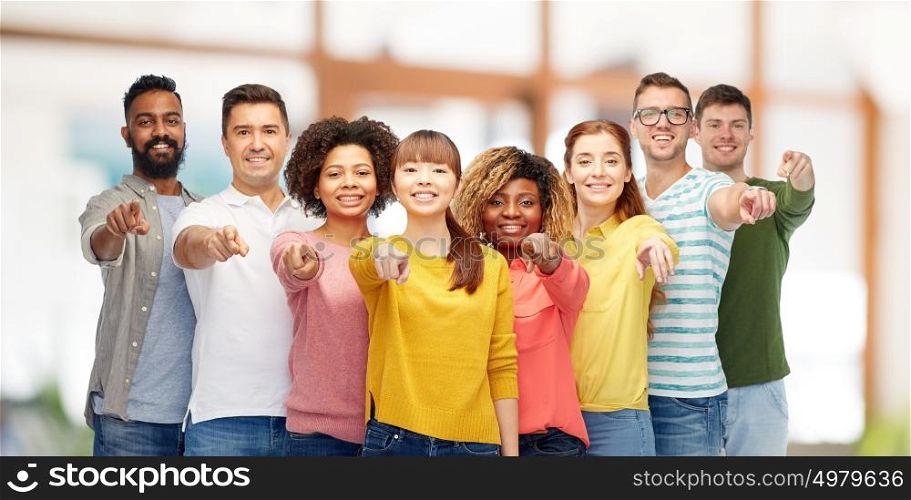 diversity, choice, ethnicity and people concept - international group of happy smiling men and women pointing finger on you over office background. international group of people pointing on you
