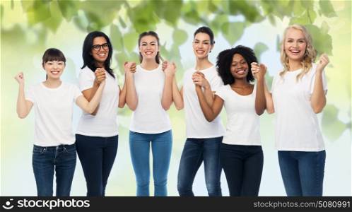 diversity, ecology and people concept - international group of happy smiling volunteer women in white blank t-shirts holding hands over green natural background. international group of happy volunteer women