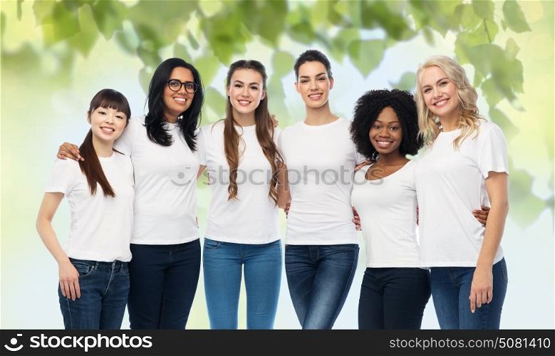 diversity, ecology and people concept - international group of happy smiling volunteer women in white blank t-shirts hugging over green natural background. international group of volunteer women hugging