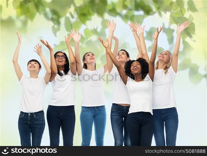 diversity, ecology and people concept - international group of happy smiling volunteer women in white blank t-shirts having fun over green natural background. international group of happy volunteer women