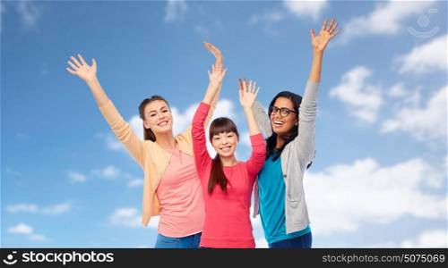 diversity, ethnicity and people concept - international group of happy smiling different women having fun over blue sky and clouds background. international group of happy smiling women