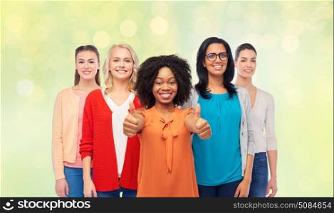 diversity, ethnicity and people concept - international group of happy smiling different women showing thumbs up over summer green lights background. international group of women showing thumbs up. international group of women showing thumbs up