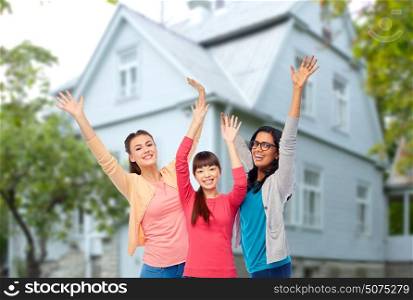 diversity, friendship and people concept - international group of happy smiling different women having fun over house background. international group of happy smiling women