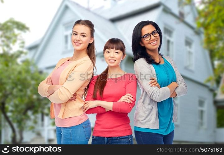 diversity, friendship and people concept - international group of happy smiling different women over house background. international group of happy smiling women