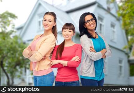 diversity, friendship and people concept - international group of happy smiling different women over house background. international group of happy smiling women