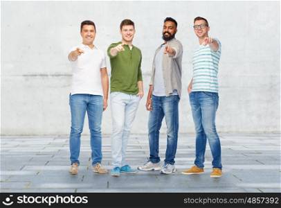 diversity, friendship, ethnicity, choice and people concept - international group of happy smiling men pointing finger to you over stone wall background