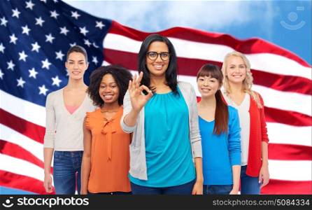 diversity, gesture and people concept - international group of happy smiling different women showing ok hand sign over american flag background. international american happy women showing ok. international american happy women showing ok