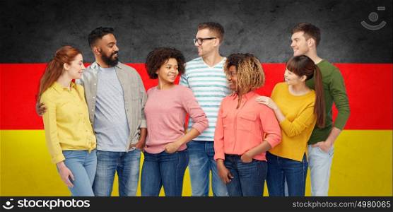 diversity, immigration and people concept - international group of happy smiling men and women over german flag background. international group of people over german flag