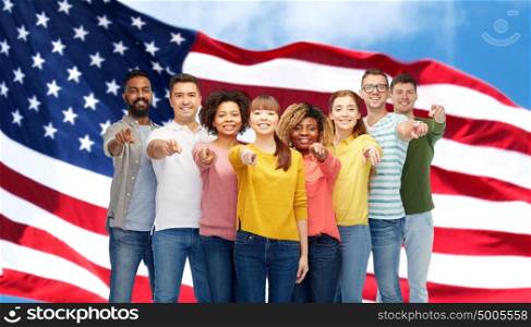 diversity, immigration and people concept - international group of happy smiling men and women pointing finger on you over american flag background. international group of people pointing on you