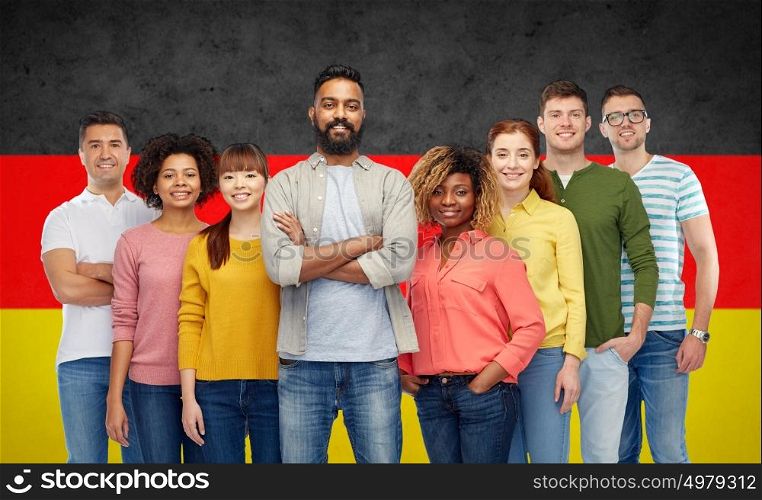 diversity, immigration, ethnicity and people concept - international group of happy smiling men and women over german flag background. international group of people over german flag