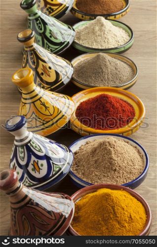 Diversity of Moroccan powder herbs in colorful ceramic tagines