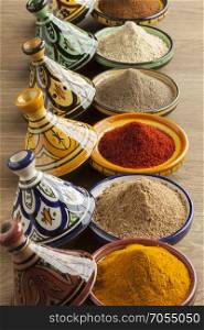 Diversity of Moroccan powder herbs in colorful ceramic tagines