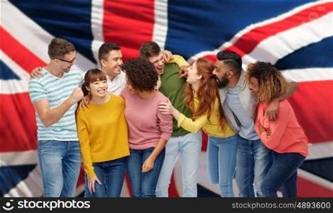 diversity, race, ethnicity and people concept - international group of happy men and women laughing over english flag background