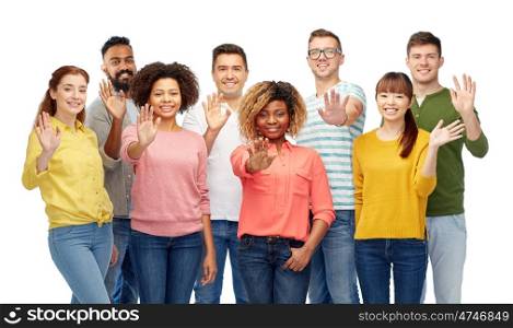 diversity, race, ethnicity and people concept - international group of happy smiling men and women waving hand over white. international group of happy people waving hand