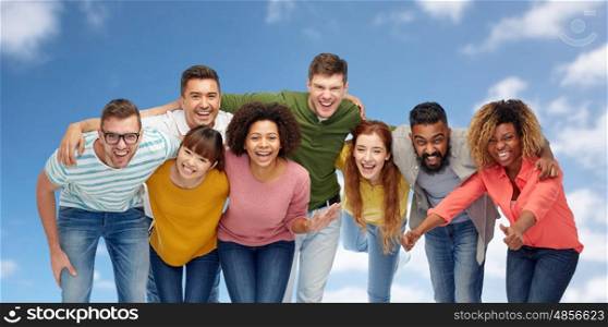 diversity, race, ethnicity and people concept - international group of happy smiling men and women over blue sky and clouds background