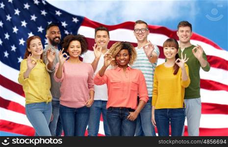 diversity, race, ethnicity and people concept - international group of happy smiling men and women showing ok hand sign over american flag background