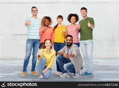 diversity, race, ethnicity and people concept - international group of happy smiling men and women showing thumbs up over wall background