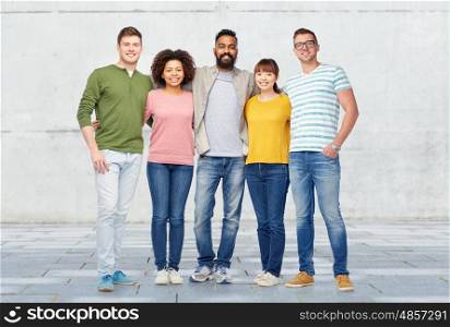 diversity, race, ethnicity and people concept - international group of happy smiling men and women over stone wall background