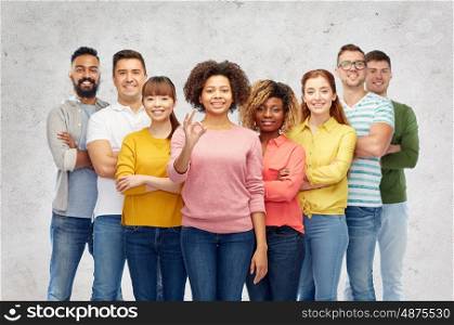 diversity, race, ethnicity and people concept - international group of happy smiling men and women showing ok hand sign over gray background