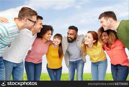 diversity, race, ethnicity and people concept - international group of happy smiling men and women over blue sky and grass background