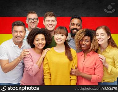diversity, race, ethnicity and people concept - international group of happy smiling men and women over german flag background