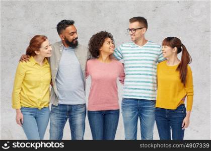 diversity, race, ethnicity and people concept - international group of happy smiling men and women over gray concrete background. international group of happy smiling people