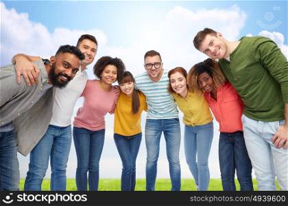 diversity, race, ethnicity and people concept - international group of happy smiling men and women hugging over blue sky background. international group of happy people hugging