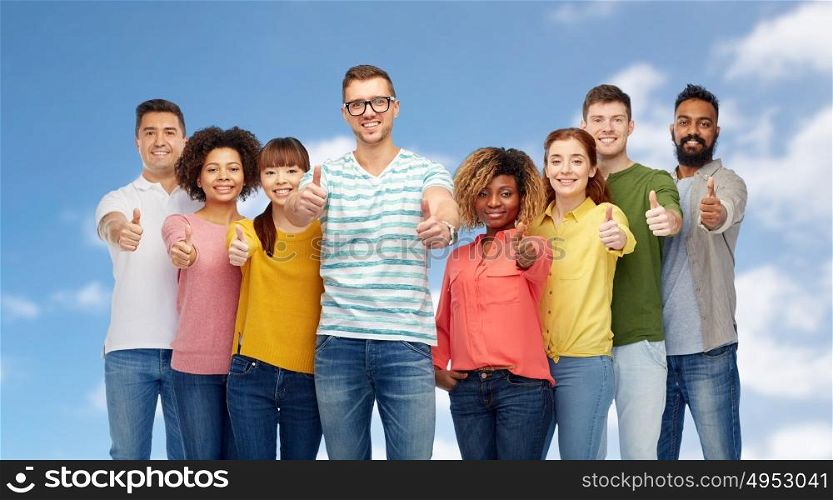 diversity, race, ethnicity and people concept - international group of happy smiling men and women showing thumbs up over blue sky and clouds background. international group of people showing thumbs up