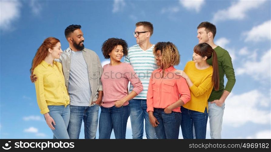 diversity, race, ethnicity and people concept - international group of happy smiling men and women over blue sky and clouds background. international group of happy smiling people