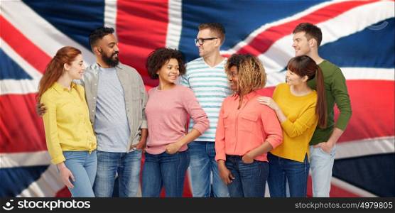 diversity, race, ethnicity and people concept - international group of happy smiling men and women over british or english flag background. international group of people over british flag