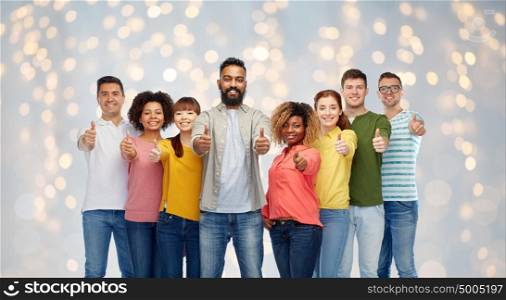 diversity, race, ethnicity and people concept - international group of happy smiling men and women showing thumbs up over holidays lights background. international group of people showing thumbs up