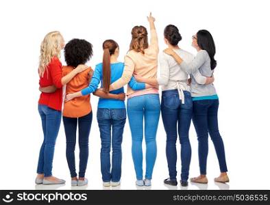 diversity, race, ethnicity and people concept - international group of happy smiling different women over white pointing finger at something. international group of happy smiling women