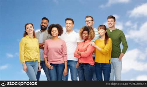 diversity, race, ethnicity and people concept - international group of happy smiling men and women over blue sky background. international group of happy people over blue sky