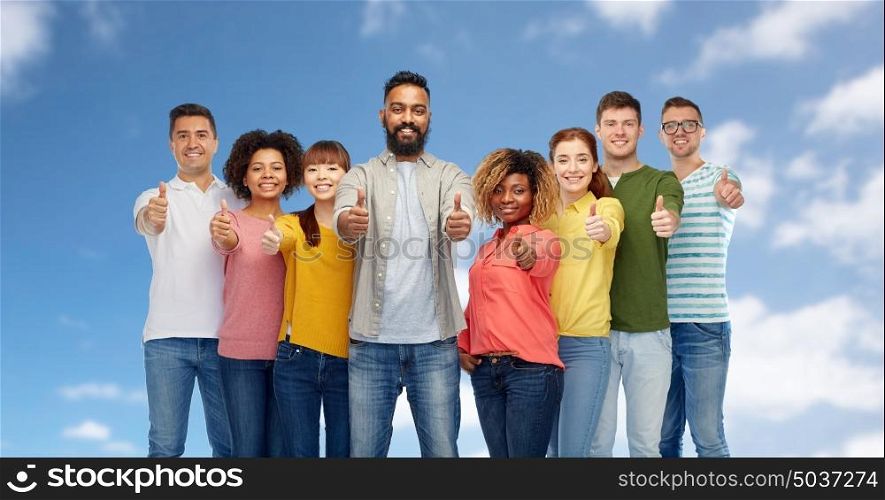 diversity, race, ethnicity and people concept - international group of happy smiling men and women showing thumbs up over blue sky background. international group of people showing thumbs up
