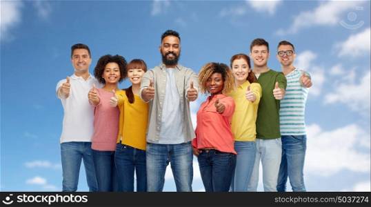 diversity, race, ethnicity and people concept - international group of happy smiling men and women showing thumbs up over blue sky background. international group of people showing thumbs up
