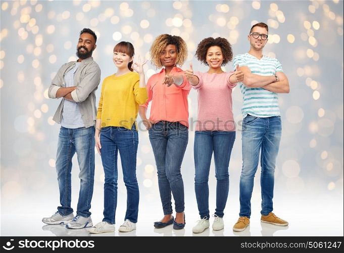 diversity, race, ethnicity and people concept - international group of happy smiling men and women over lights background. international group of happy people over lights