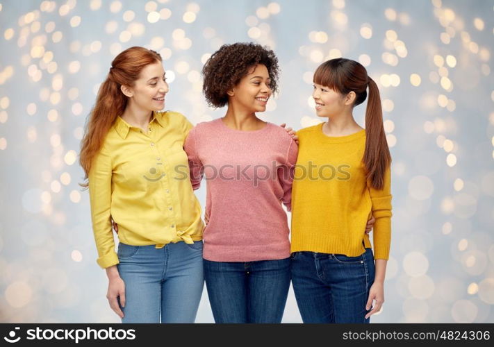 diversity, race, ethnicity, friendship and people concept - international group of happy smiling women hugging over holidays lights background