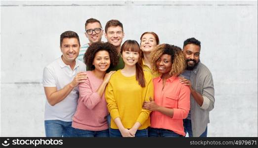 diversity, race, ethnicity, friendship and people concept - international group of happy smiling men and women over stone wall background. international group of happy smiling people