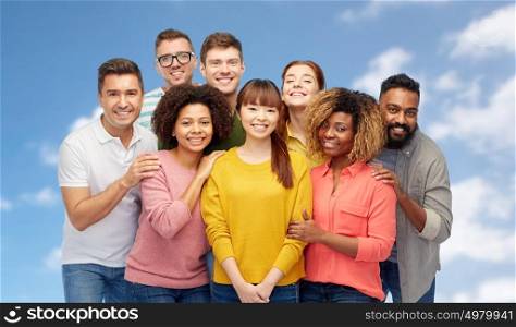 diversity, race, ethnicity, friendship and people concept - international group of happy smiling men and women over blue sky and clouds background. international group of happy smiling people